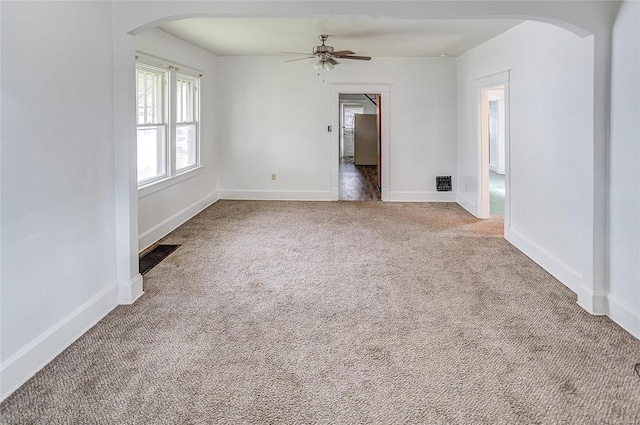 carpeted spare room with ceiling fan