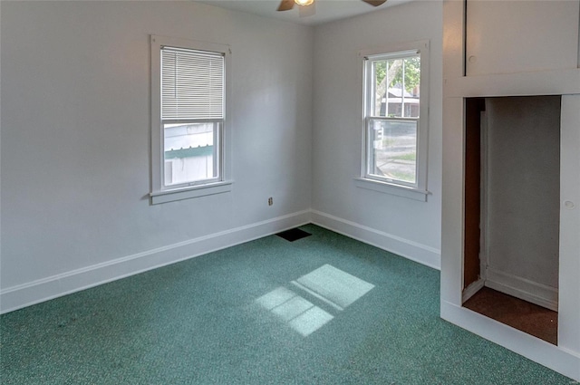 empty room featuring ceiling fan and carpet