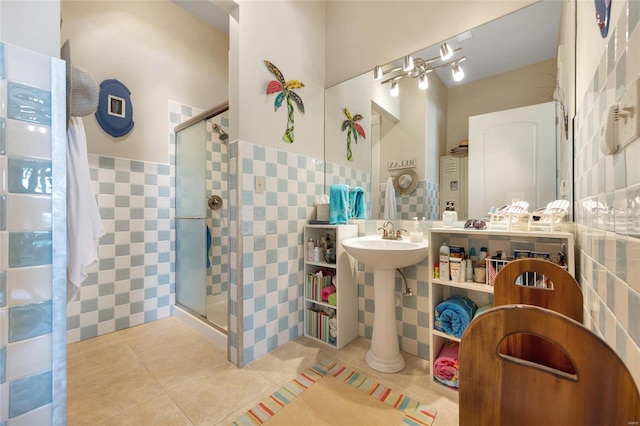 bathroom with a shower with door, tile patterned flooring, and tile walls