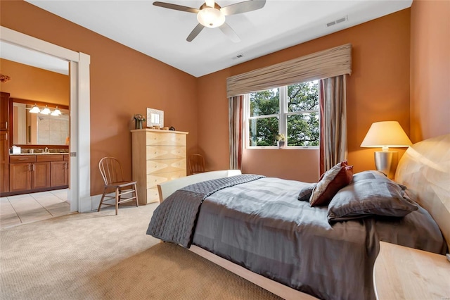 carpeted bedroom featuring ceiling fan and ensuite bath