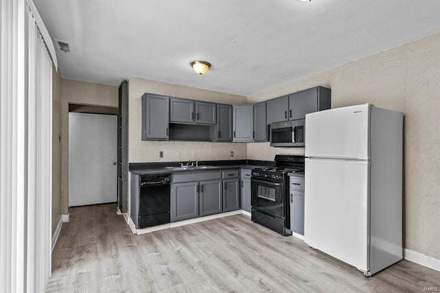 kitchen featuring gray cabinets, sink, black appliances, and light wood-type flooring