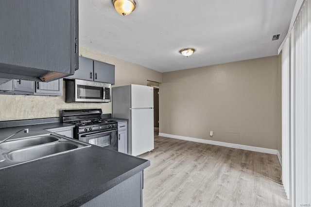 kitchen featuring gray cabinets, sink, light hardwood / wood-style floors, and stainless steel appliances