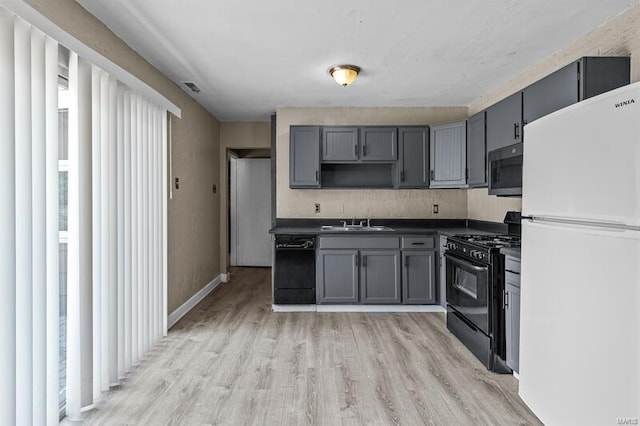 kitchen featuring black appliances, plenty of natural light, gray cabinets, and sink