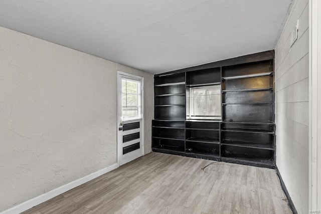 empty room with hardwood / wood-style flooring and built in features