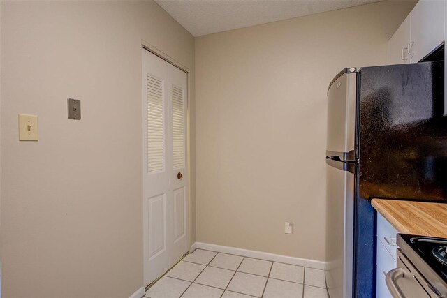 kitchen featuring white cabinets, light tile patterned floors, and stainless steel appliances