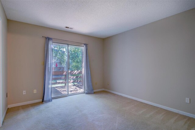 unfurnished room with light carpet and a textured ceiling