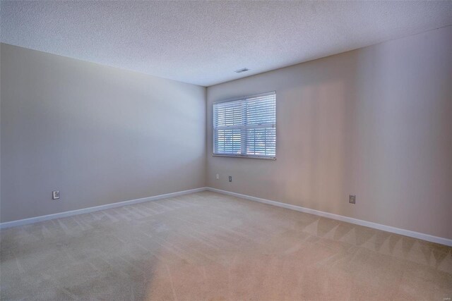 carpeted empty room with a textured ceiling