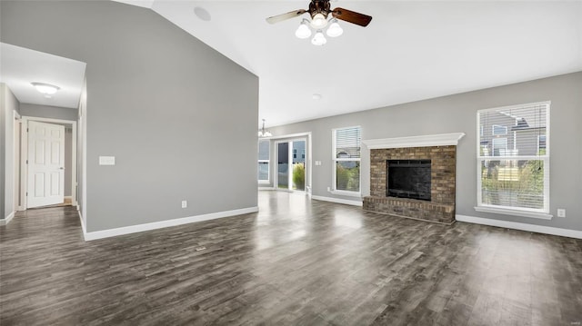 unfurnished living room featuring ceiling fan with notable chandelier, dark hardwood / wood-style floors, lofted ceiling, and a fireplace