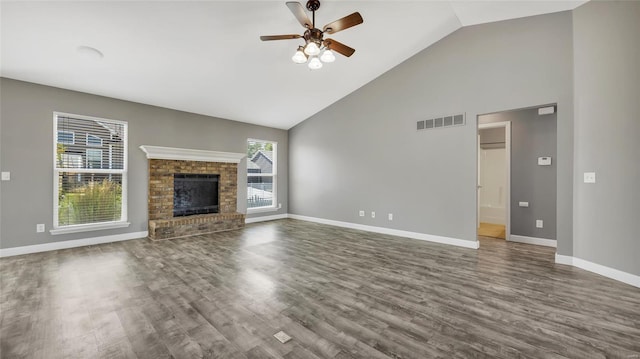 unfurnished living room with hardwood / wood-style flooring, ceiling fan, a fireplace, and high vaulted ceiling