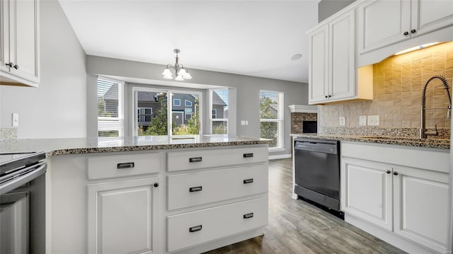 kitchen featuring decorative backsplash, light stone countertops, dishwasher, a chandelier, and white cabinetry