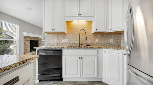 kitchen with stainless steel refrigerator, dishwasher, sink, decorative backsplash, and white cabinets