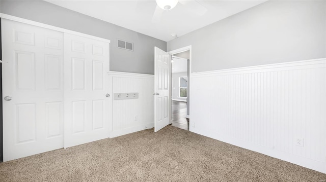 unfurnished bedroom featuring ceiling fan, a closet, and carpet