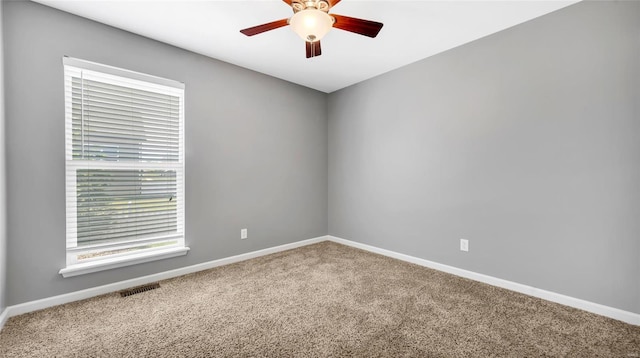 empty room featuring ceiling fan and carpet