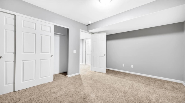 unfurnished bedroom with light colored carpet and a closet