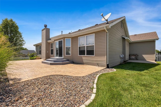 rear view of house with a lawn and a patio