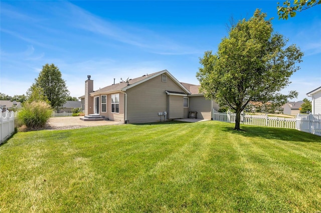 rear view of house featuring a lawn and a patio