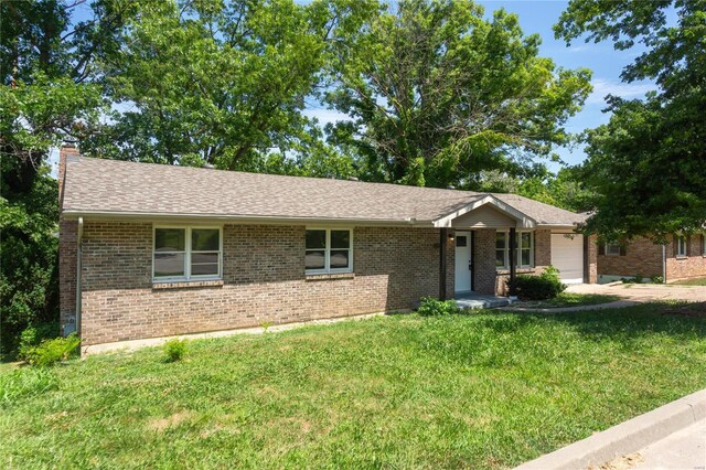 ranch-style home with a garage and a front yard