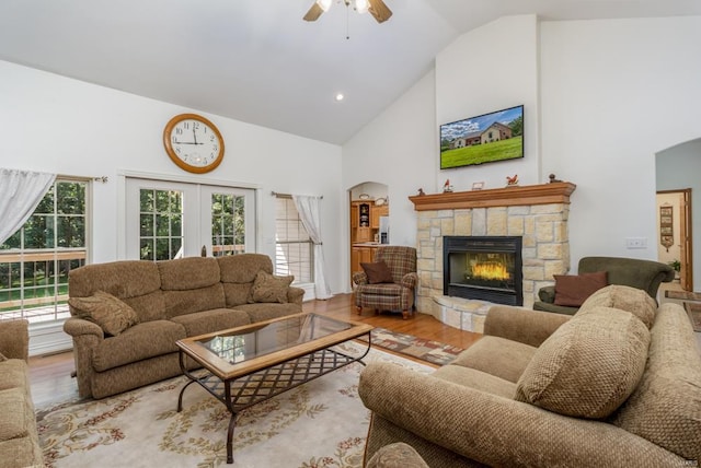 living room featuring plenty of natural light, ceiling fan, light wood-type flooring, and a fireplace