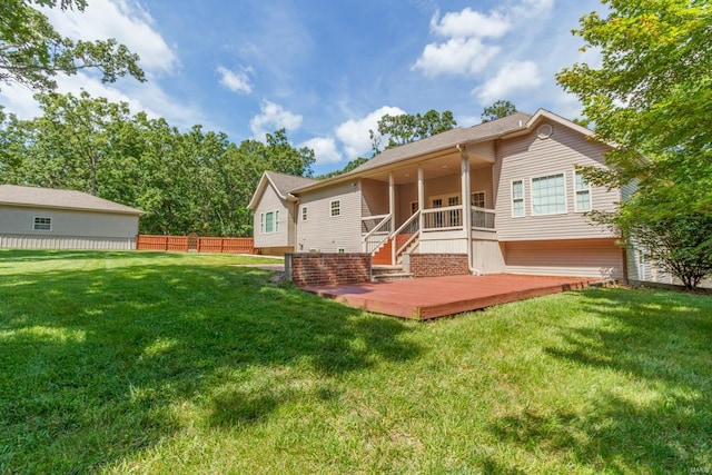 back of property with a wooden deck and a yard