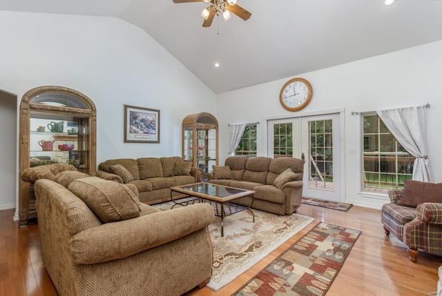 living room with french doors, ceiling fan, high vaulted ceiling, and light hardwood / wood-style flooring