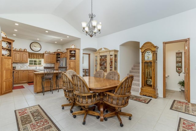 dining area featuring lofted ceiling, light tile patterned floors, and a notable chandelier