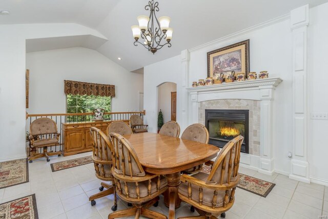 tiled dining room featuring a tiled fireplace, vaulted ceiling, and a chandelier