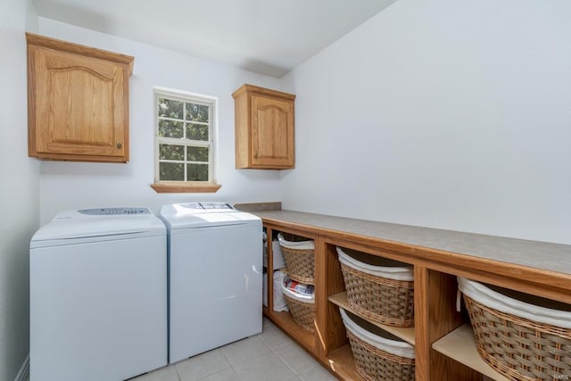 washroom with separate washer and dryer, cabinets, and light tile patterned floors