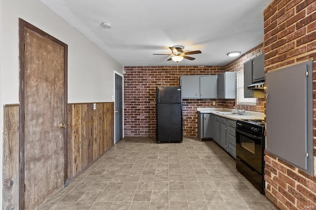 kitchen featuring brick wall, gray cabinets, ceiling fan, and black appliances