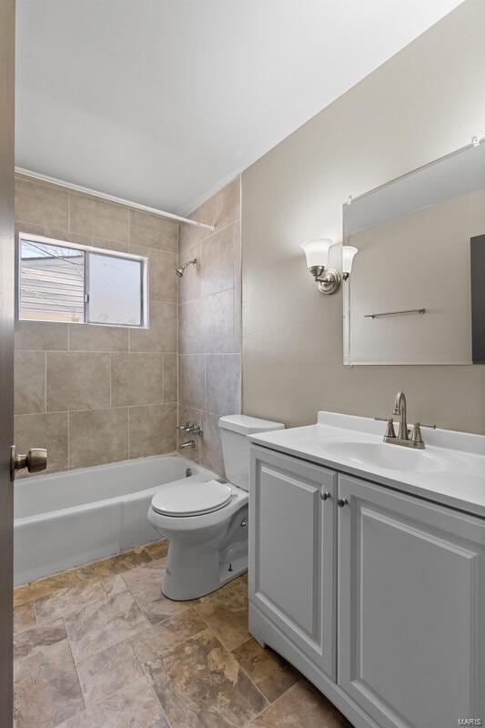 full bathroom featuring toilet, vanity, and tiled shower / bath