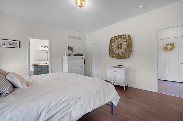 bedroom featuring dark hardwood / wood-style flooring and ensuite bathroom