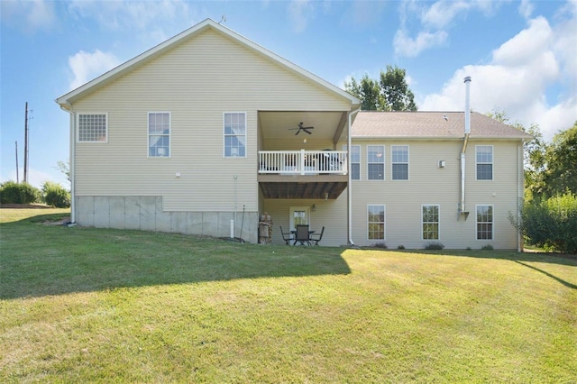 rear view of house featuring a yard and ceiling fan