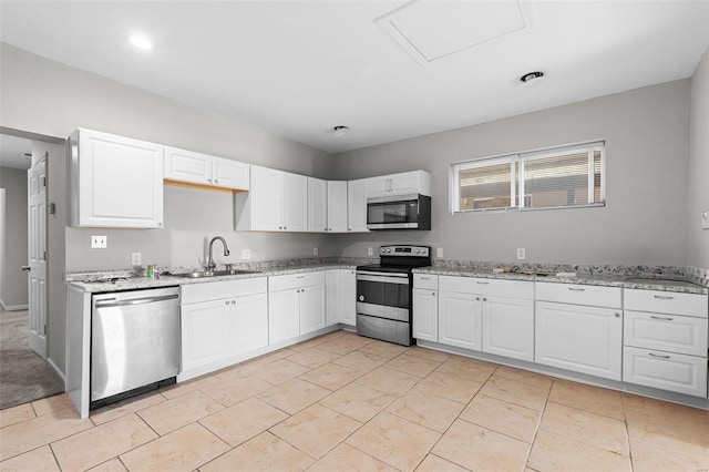 kitchen with light stone countertops, appliances with stainless steel finishes, sink, and white cabinets