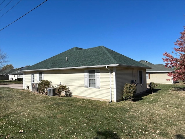 view of side of home with central air condition unit and a lawn