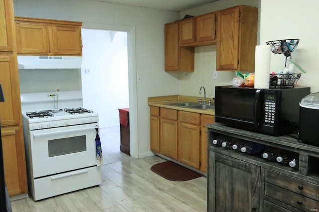 kitchen with sink, light hardwood / wood-style floors, and white gas range oven