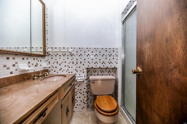 bathroom with vanity, tile patterned floors, tile walls, and a shower with shower door