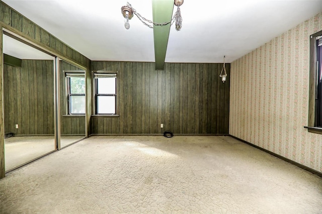 unfurnished room featuring wooden walls