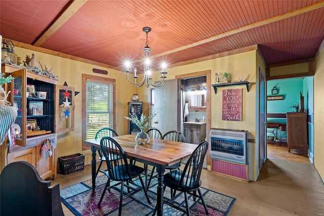 dining room with hardwood / wood-style flooring, an inviting chandelier, wooden ceiling, and heating unit