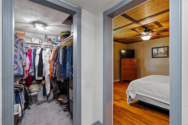 bedroom featuring lofted ceiling, hardwood / wood-style flooring, ceiling fan, a textured ceiling, and a closet