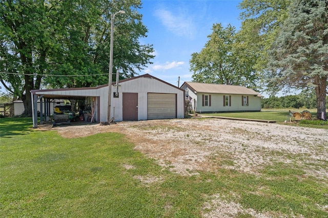 view of front of house with a front lawn, a garage, a carport, and an outdoor structure