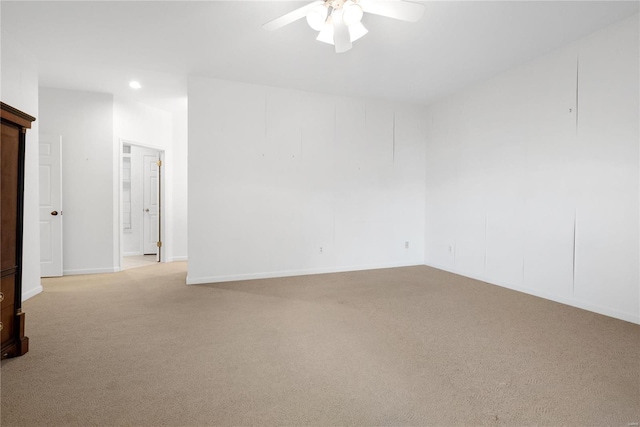 spare room with light colored carpet and ceiling fan