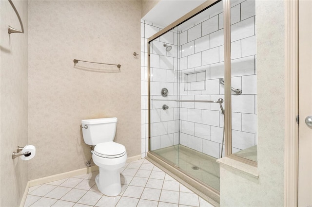 bathroom featuring tile patterned flooring, toilet, and walk in shower