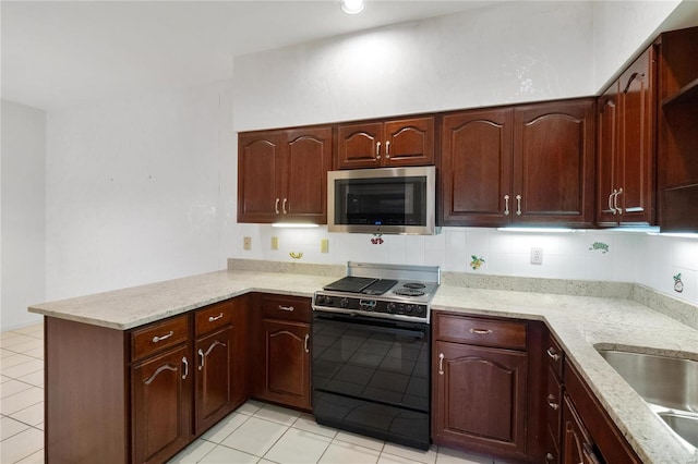 kitchen with black stove, decorative backsplash, light stone countertops, and kitchen peninsula