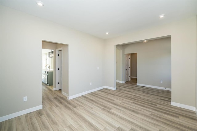 spare room with light wood-type flooring and sink