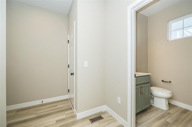 bathroom with hardwood / wood-style floors, vanity, and toilet