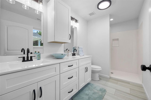 bathroom featuring vanity, walk in shower, and toilet