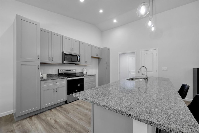 kitchen featuring sink, gray cabinets, stainless steel appliances, light hardwood / wood-style floors, and decorative light fixtures