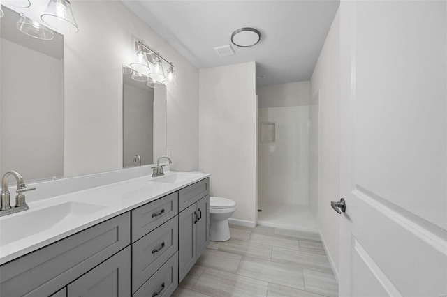 bathroom featuring walk in shower, vanity, and toilet