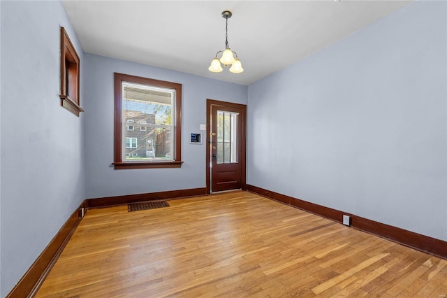 foyer entrance with a notable chandelier and light hardwood / wood-style floors