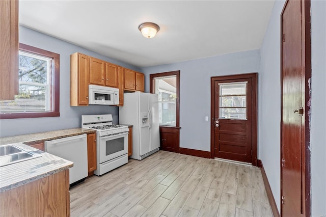 kitchen with light hardwood / wood-style floors and white appliances