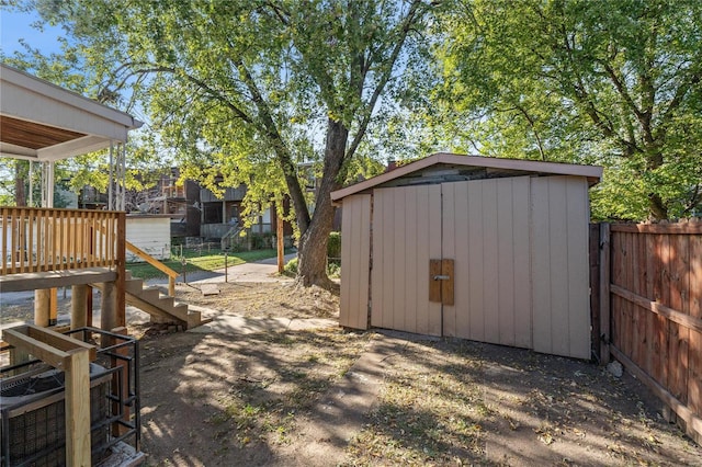 view of yard featuring a wooden deck and a storage shed